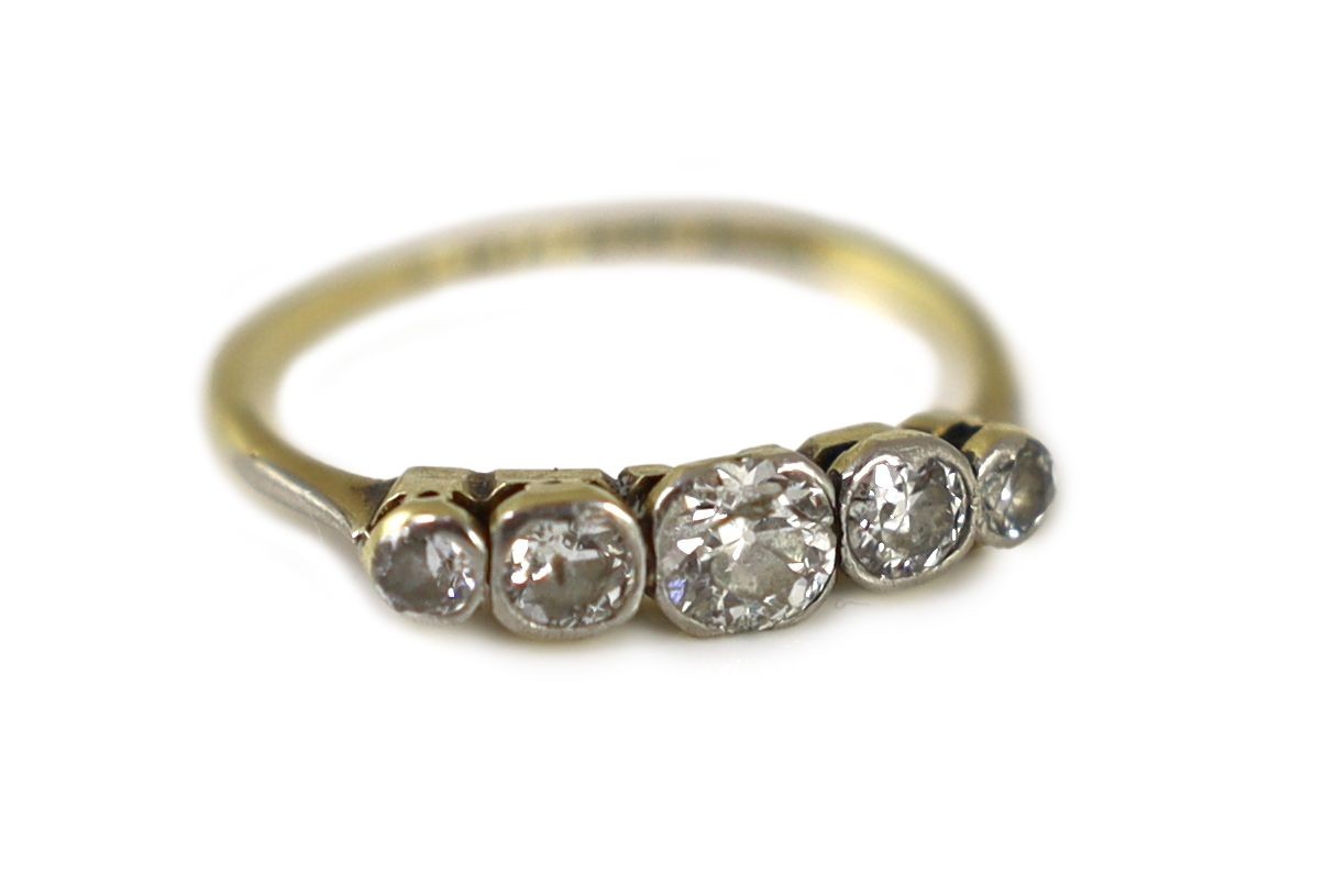 An early 20th century 18ct gold, platinum and graduated collet set five stone diamond ring